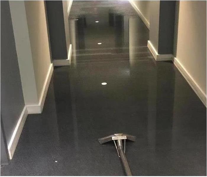 Image of marble hallway with water cleaning vacuum on floor