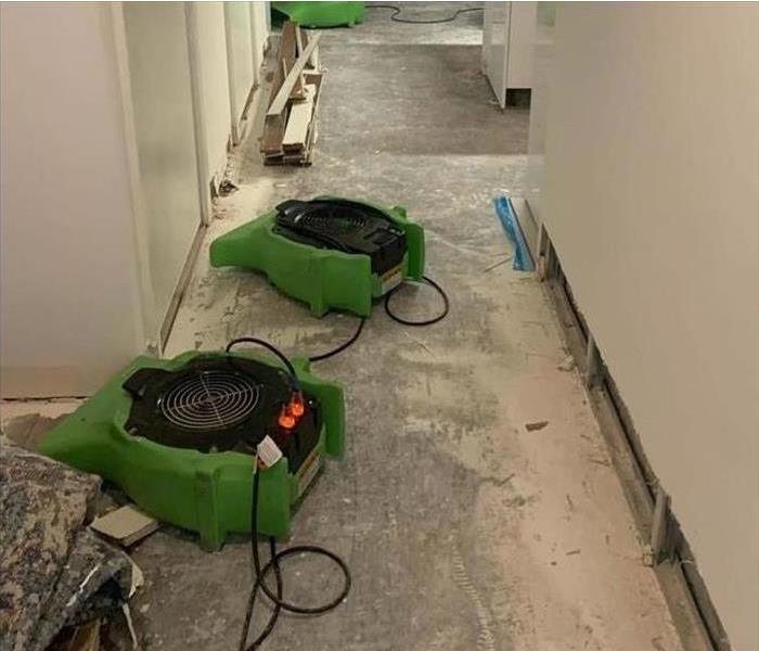 two air movers placed on the floor, drying equipment on damaged area